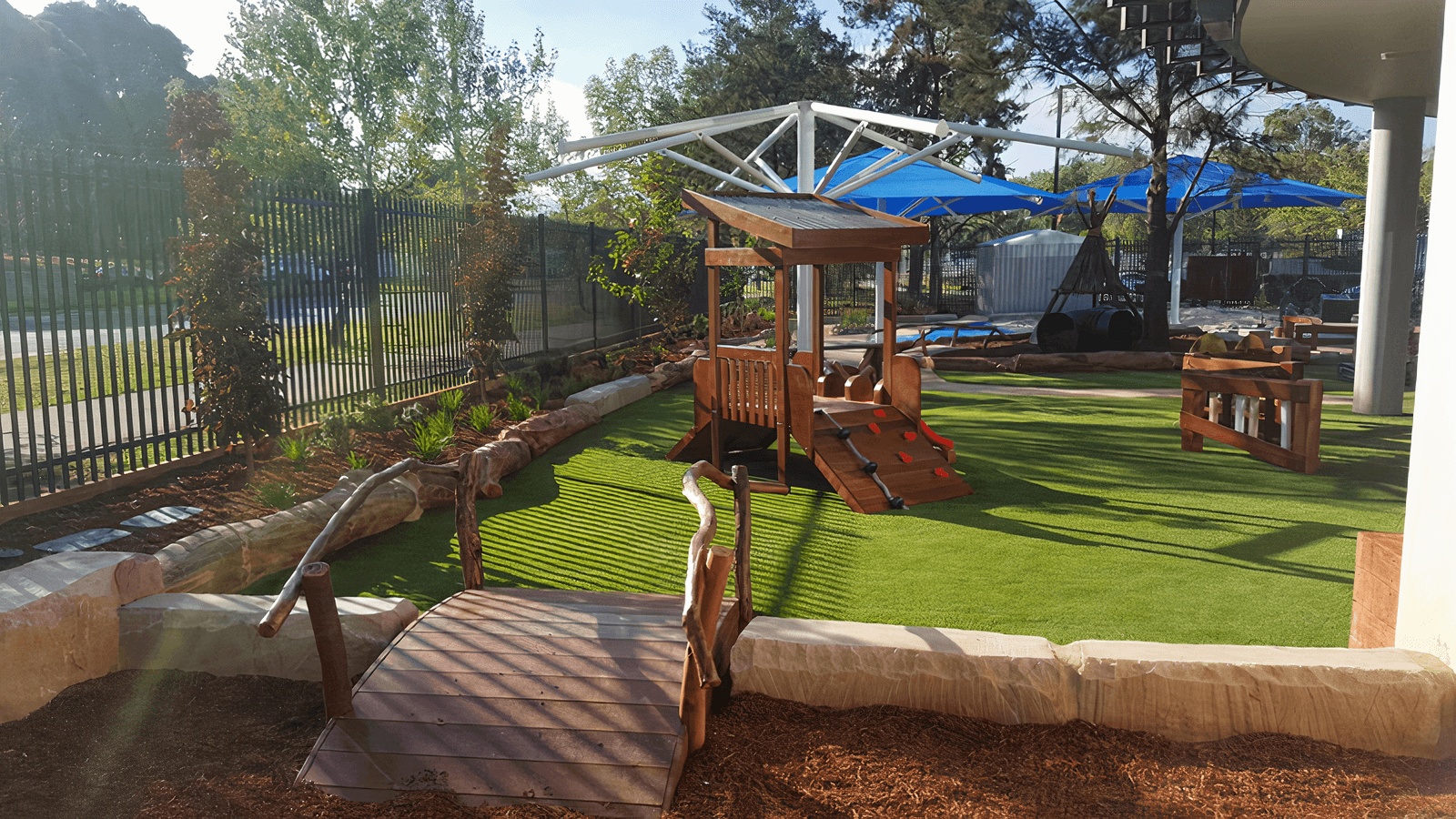 Shaded play area with bridge